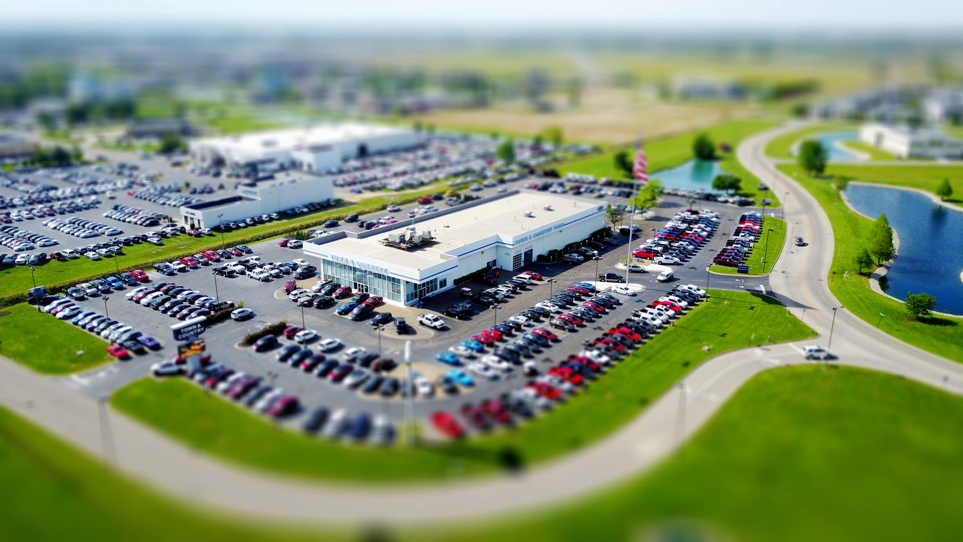 Vista aérea de um grande estacionamento de concessionária