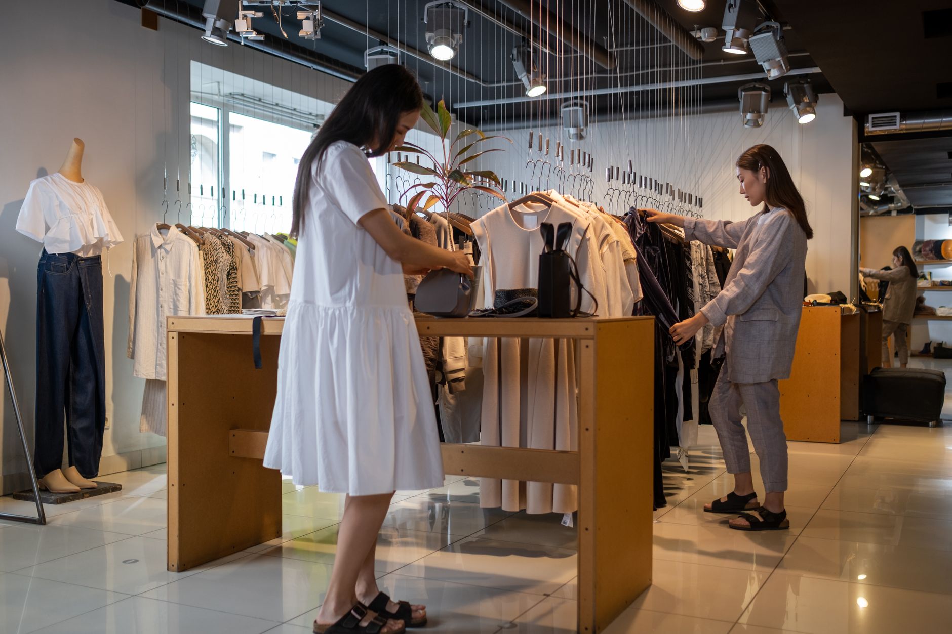 Clientes escolhendo roupas em uma loja movimentada